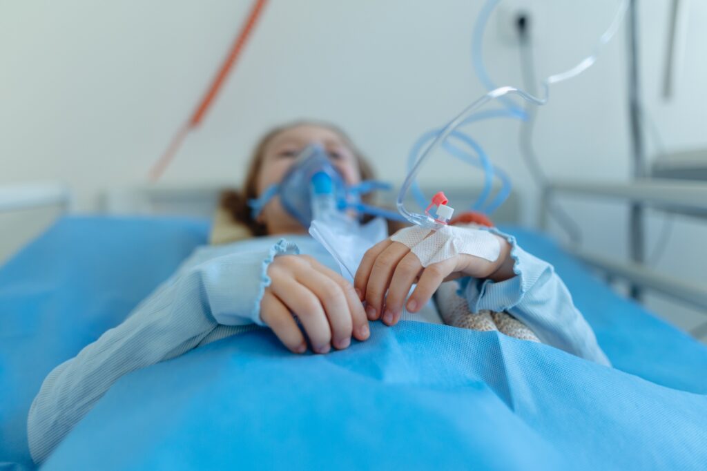 Close-up of little girl with infection disease lying in hospital room.
