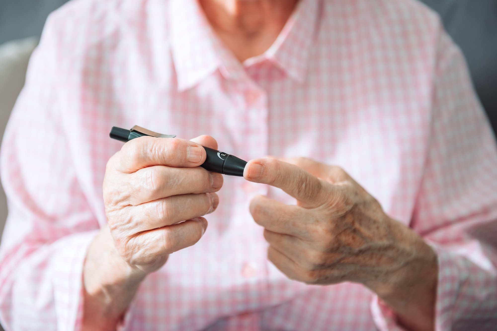 Diabetic mature woman hold use blood glucose meter, old senior adult lady check morning insulin