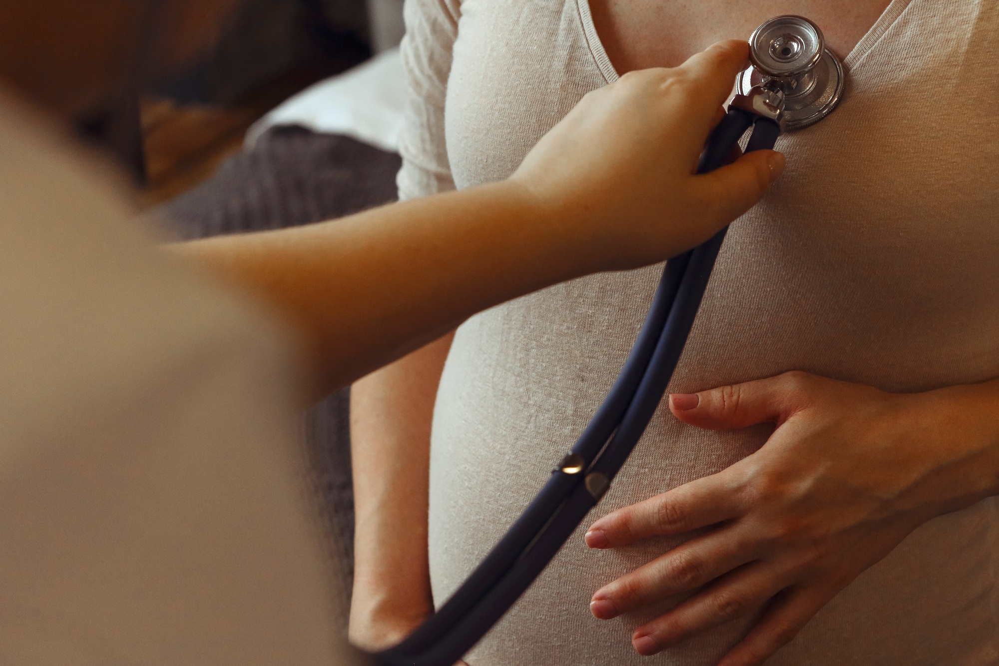 Doctor listening to pregnant woman heartbeat with stethoscope. Cardiac disease in pregnancy