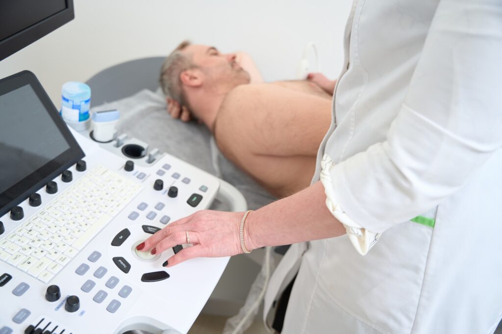 Doctor using ultrasound machine to scan of a senior male patient