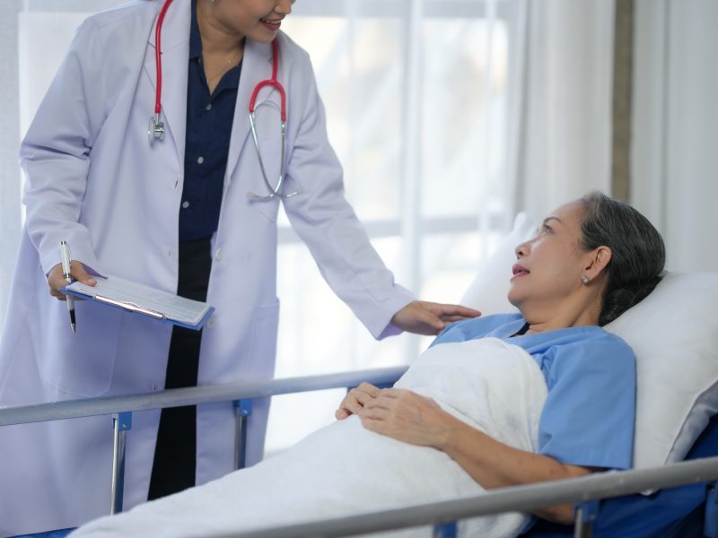 Doctor caring for a patient in a hospital bed, providing comfort and medical support during